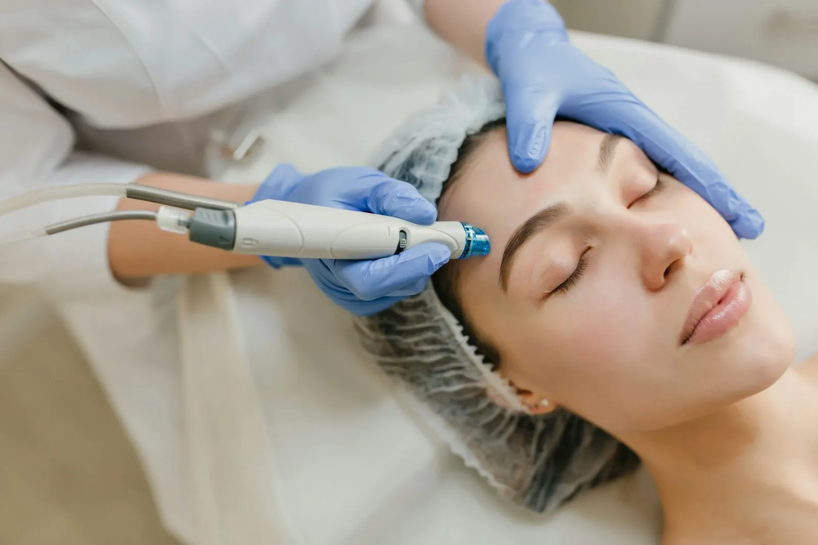 Tratamiento facial con aparatología mientras la clienta descansa con los ojos cerrados